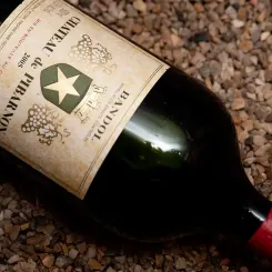 Une bouteille de Château de Pibarnon 2005 couchée sur des cailloux